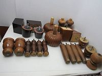 Photo showing various vintage wood furniture legs of different shapes and sizes, screws attached for mounting, arranged on white surface.