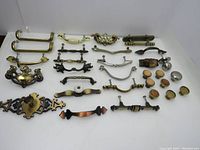 Full set of 31 vintage individual drawer pullers and knobs arranged on a white background, showing various styles and finishes including brass, metal, wood, and ceramic.