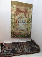 Full front view of the angel tapestry hanging on wall, showing classical architectural background and floral details