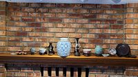 Wide shot of the full assortment of Asian decor including jars, vases, dishes, and decorative sphere.