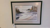 Full view of framed scenic watercolor painting of water and trees.
