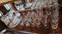 Glass and crystal stemware displayed on a wooden surface showing multiple wine and champagne glasses with textured stems.