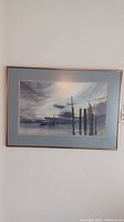 Full view of framed watercolor painting showing seascape scene with pilings.