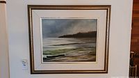 Framed original artwork showing entire seascape painting with waves, shore, and trees.
