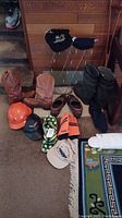 Overview of hats, boots, shoes, shoe racks, shoe saver, and boot tray arranged on carpet next to stairs