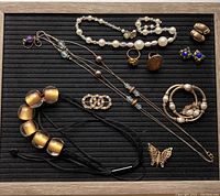 All jewelry items laid out showing three necklaces, two brooches, two rings, one bracelet, and one pair of clip-on earrings.