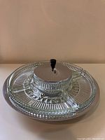 Single image of the Kromex Lazy Susan with four glass inserts and central lidded bowl from an angle, showing base and glass detail.