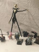 Wide-angle photo showing the large 13-inch Jack Skellington figure accompanied by multiple smaller character figurines including Sally, Oogie Boogie, Lock, Shock, Barrel, Easter Bunny, Behemoth, Vampire, and Mayor with megaphone, along with various small prop pieces.