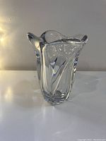 Front angled view of the clear heavy glass vase showing the swooping curved edges and linear design.