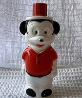 Front view of vintage Mickey Mouse shaped plastic Soaky soap bottle with red cap, showing detailed face and red shirt.