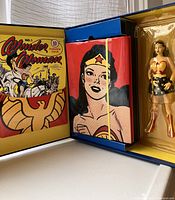 Opened collector's box showing the Wonder Woman action figure, the hardcover illustrated book, and cover art of the comic facsimile inside.