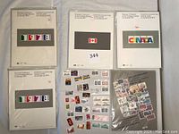 Overview of five Canadian souvenir stamp collection albums from 1977 to 1980. One 1978 album is opened showing loose stamps; the others are still sealed in plastic.