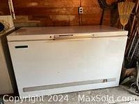 Front view of a large white Continental 507 chest freezer with closed lid, showing surface wear.