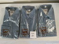 Three vintage Lee Western shirts in original plastic packaging, blue denim appearance with snap buttons and Lee logo on pocket