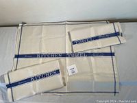 Three vintage linen kitchen towels spread and folded showing blue stripes and text 'Linen KITCHEN TOWEL Made in Ireland'