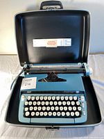 Typewriter inside the open carrying case, showing keys and body.