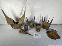 Full view of all seven vintage Sumatran architectural metal models showing varying sizes and levels of detail