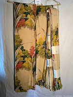 Four vintage drape panels shown folded and hanging; fabric has a leafy design in muted colors.