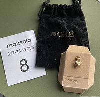 Photo of the 10 KT gold heart pendant on the Peoples Jewellers display card with original pouch beside it.