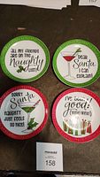 Overview of all four Christmas-themed side plates with colorful rims and holiday sayings displayed on a dark surface.