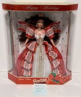 Front view of Barbie doll in original packaging, showing detailed holiday-themed dress and accessories.