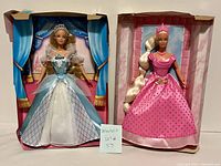 Both barbies posed together in their display cardboard backs, dressed as Sleeping Beauty and Rapunzel