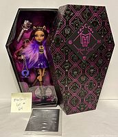 Photo of the sealed Monster High Clawdeen Wolf doll in coffin-shaped box with certificate and accessories visible.