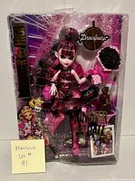 Full view of Monster High Draculara Monster Ball doll in sealed package showing the packaging, doll in bat-themed dress, and boxed accessories.