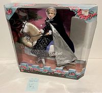 Front view of boxed Barbie Royal Romance doll sitting on white horse in original packaging with floral and castle artwork.