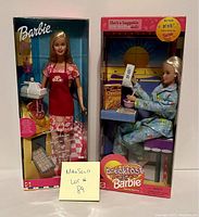 Both Barbie dolls in original boxes showing 1999 Cheerios Breakfast Barbie and 2001 Baking Fun Barbie side by side.