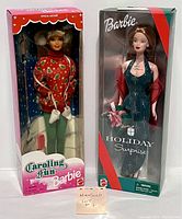 Both dolls side by side in original display boxes showing front view of packaging and dolls