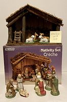 Photo of the wooden stable and original box with several ceramic figurines arranged in front.