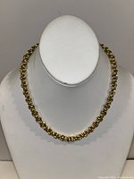 Full view of gold rope chain on white display bust