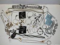 Overview of assorted jewelry pieces laid out on a flat surface. Includes multiple necklaces, bracelets, earrings, and bangles in various styles and brands.
