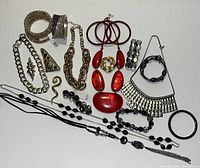 Photo showing full assortment of mixed metal and glass jewelry including bracelets, necklaces, earrings, and pins.