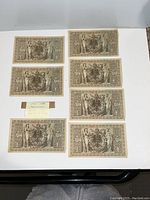 Eight German Reichsbanknotes laid out, showing detailed classical imagery and inscriptions in German.