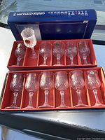 Set of twelve crystal stemware glasses in original red insert tray and blue Crystal d'Argences box. Glasses have etched patterns and original labels on some.