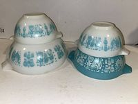 Four Pyrex Cinderella bowls nested and stacked, showing size variation and distinct turquoise and white Amish Butterprint pattern.