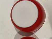 Bottom view of one red and white Pyrex mixing bowl showing its markings