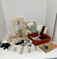 Lot of vintage sewing embellishments arranged showing pearl collars, lace trims, beaded appliques, ribbons, lace on spools, and other decorative sewing items.