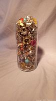 Full glass jar packed with assorted costume rings of various colors and styles