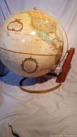Full view of the 16 inch diameter Replogle World Classic Series globe mounted on a curved wooden desk stand showing North America.