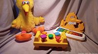 Photo showing the Big Bird plush, shape sorter toy, and Big Bird xylophone together