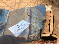 Rolled rugs placed on a neutral patterned floor, showing size label 34x60 inches on the largest rug.