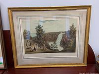 Frontal view of framed print showing waterfall scene and group of figures, decorative gilt frame.