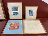 Four framed art prints displayed on a flat surface, showing size and framing style.