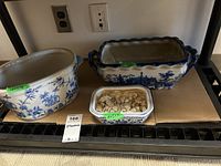 All three ceramic planters displayed on a shelf, showing size variations and decorative patterns.