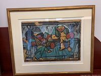 Full view of the framed signed art print with abstract imagery in earth tones and a gold frame.