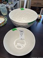 Two white Spode embossed bowls on a table showing overall sizes