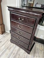 Front view showing five drawers and metal handles, visible wear and surface scrapes.